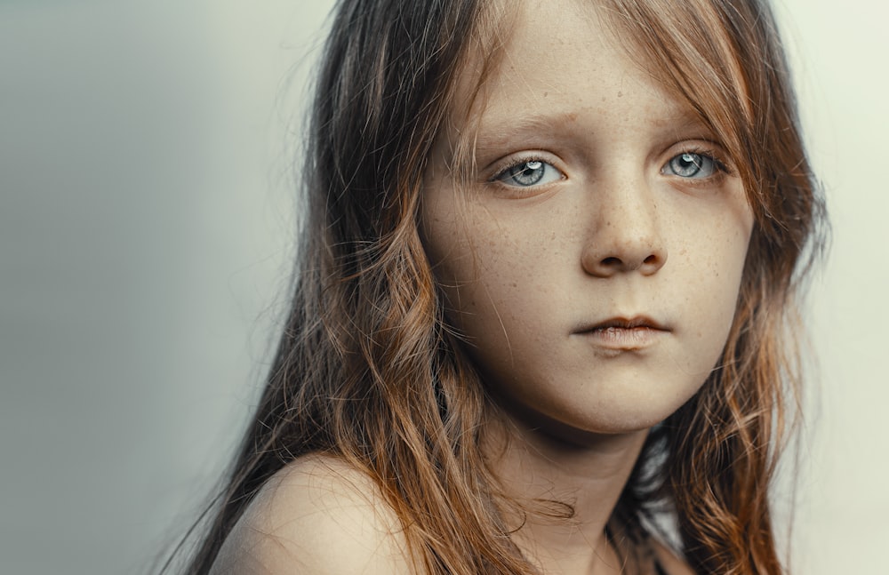 a close up of a young girl with blue eyes