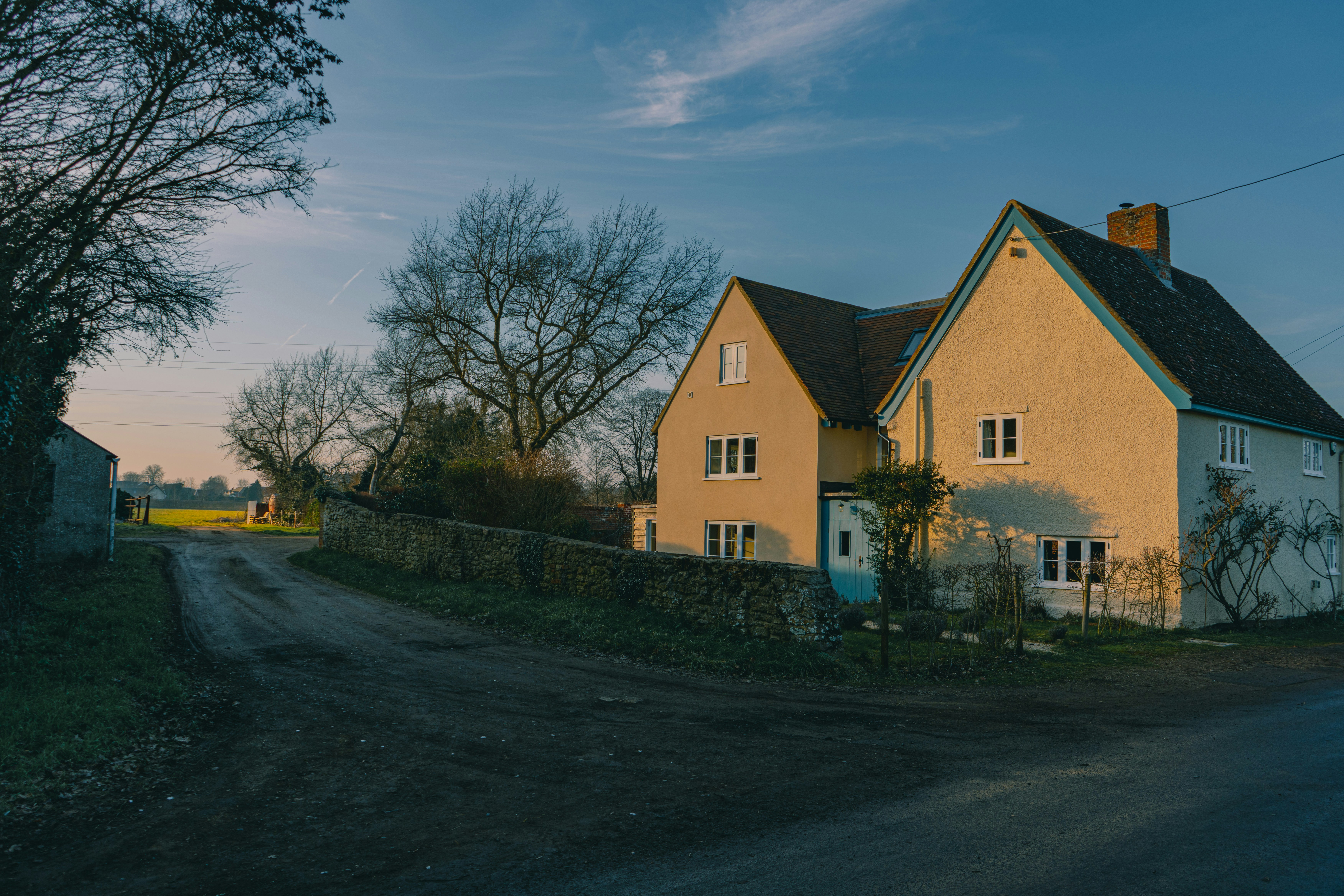 a yellow house sitting on the side of a road