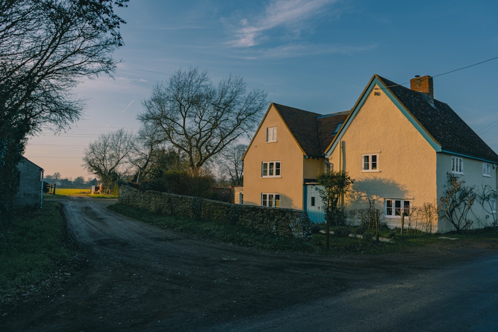 a yellow house sitting on the side of a road