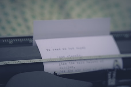 A close-up of a typewriter with a half-finished story on the paper, surrounded by scattered notes.