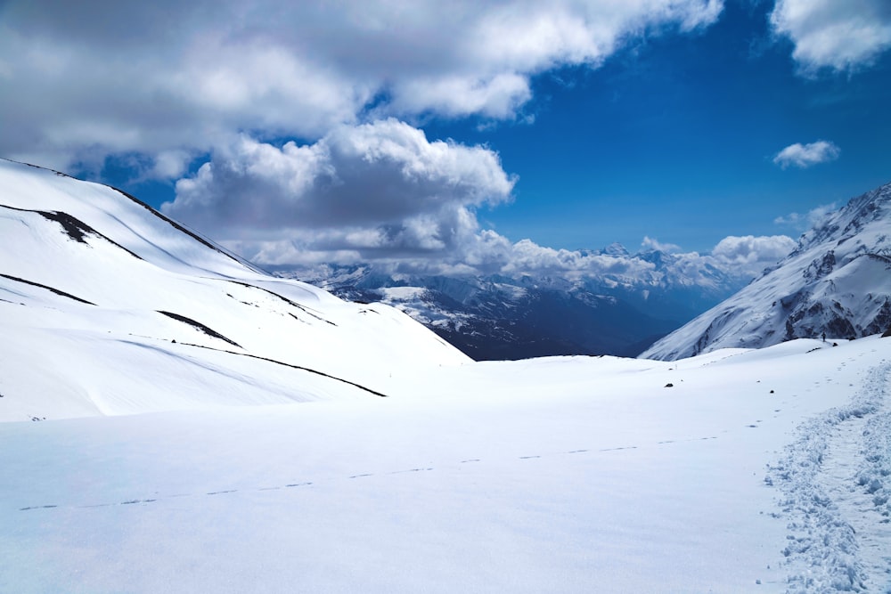 a snow covered mountain with tracks in the snow