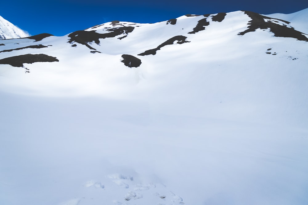 a man riding skis down a snow covered slope