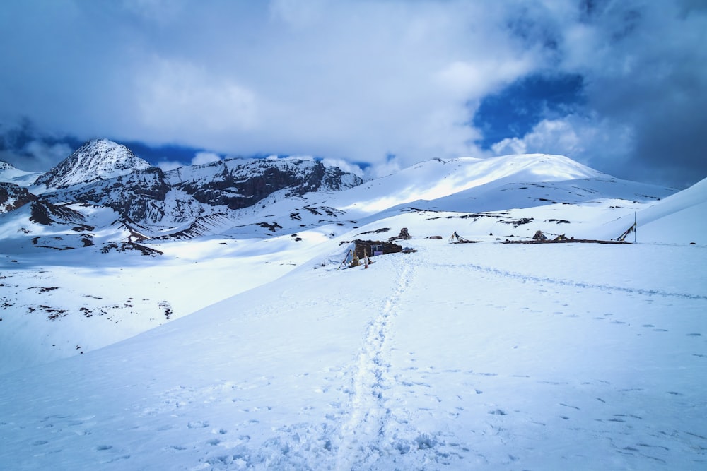 a snow covered mountain with tracks in the snow