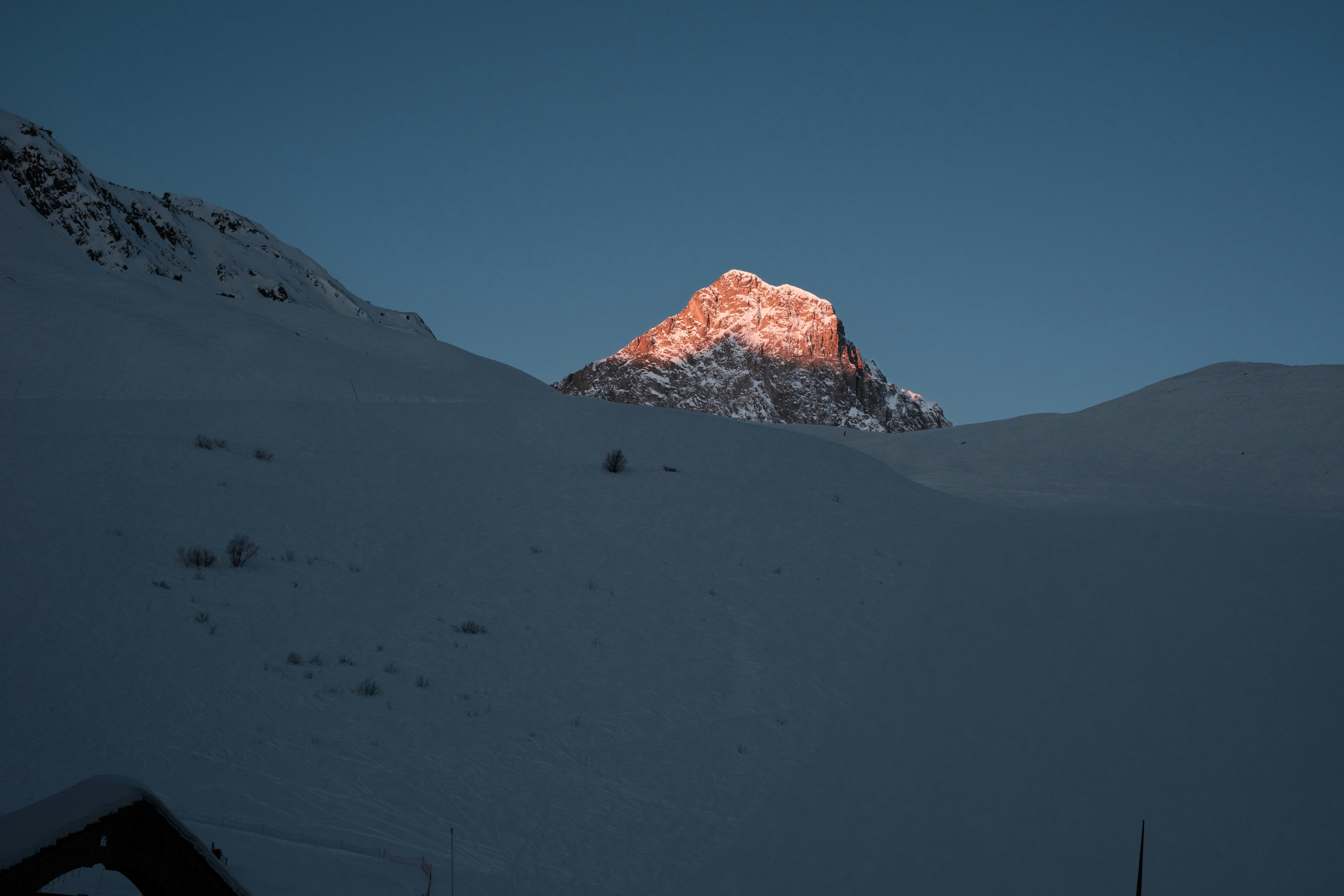 una montagna innevata con il sole che splende su di essa