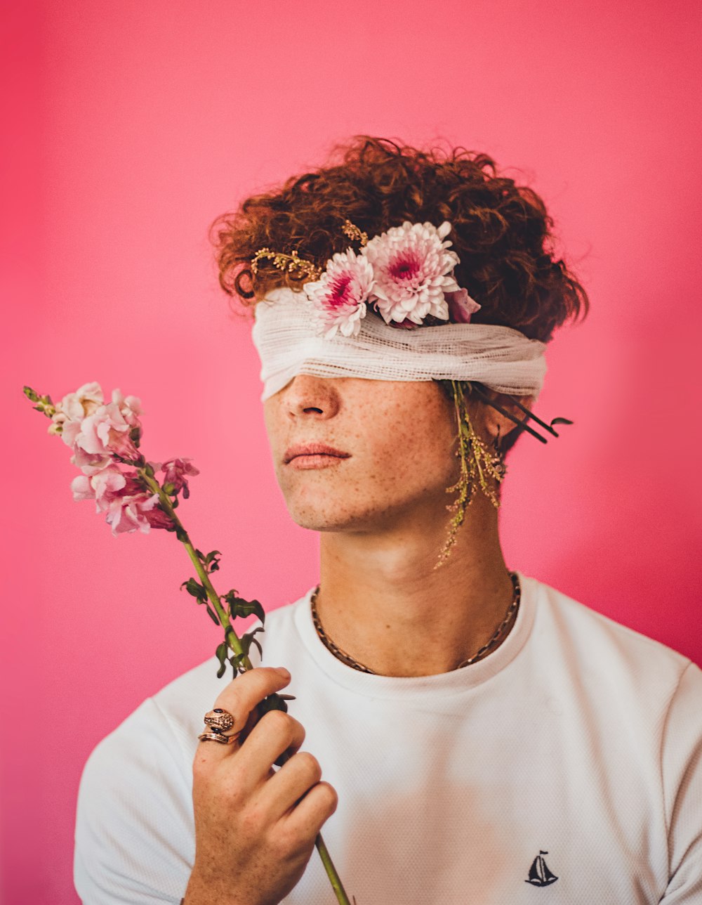 a man wearing a blindfold holding a flower