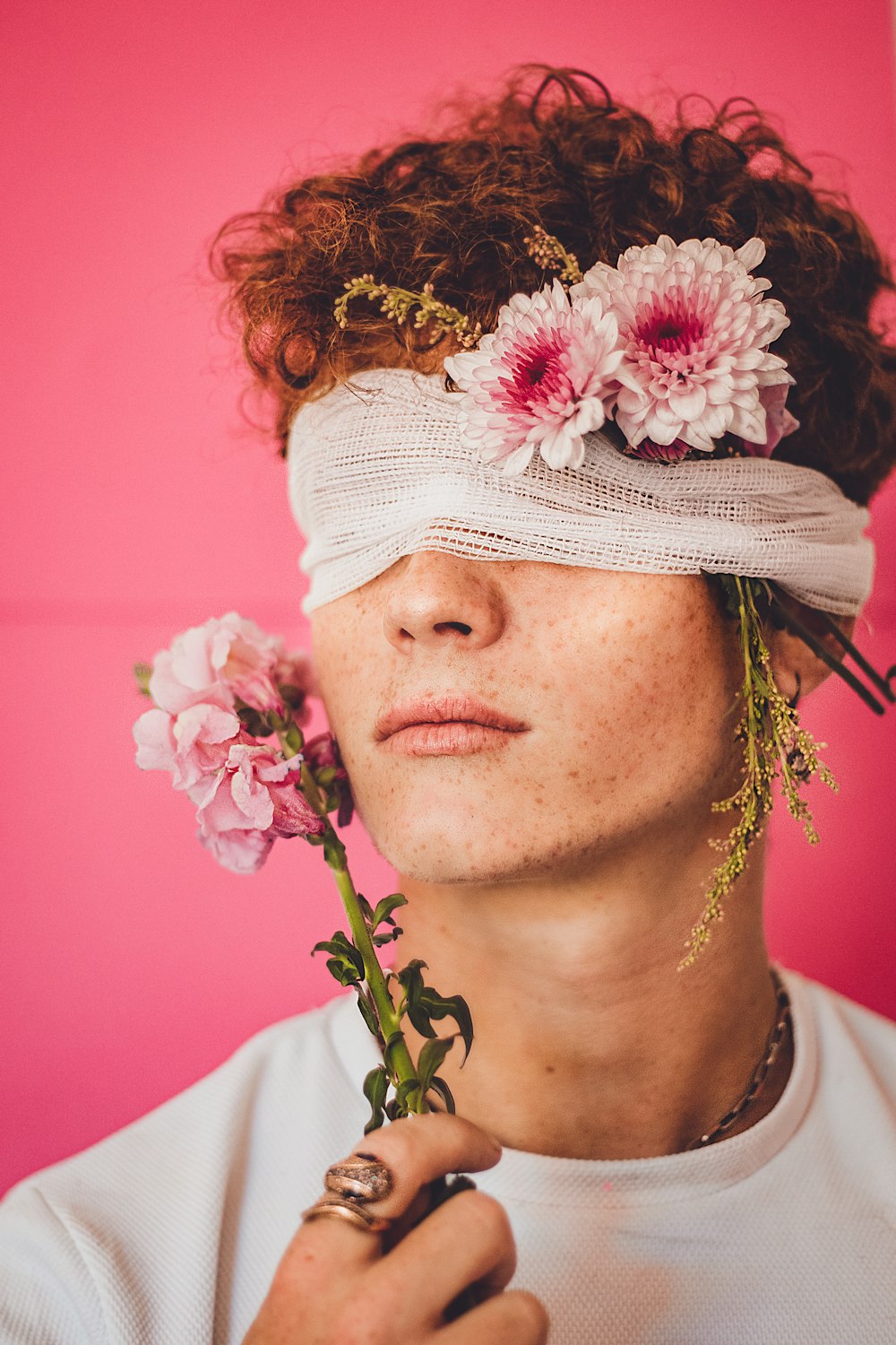 a woman with a blindfold and flowers in her hair
