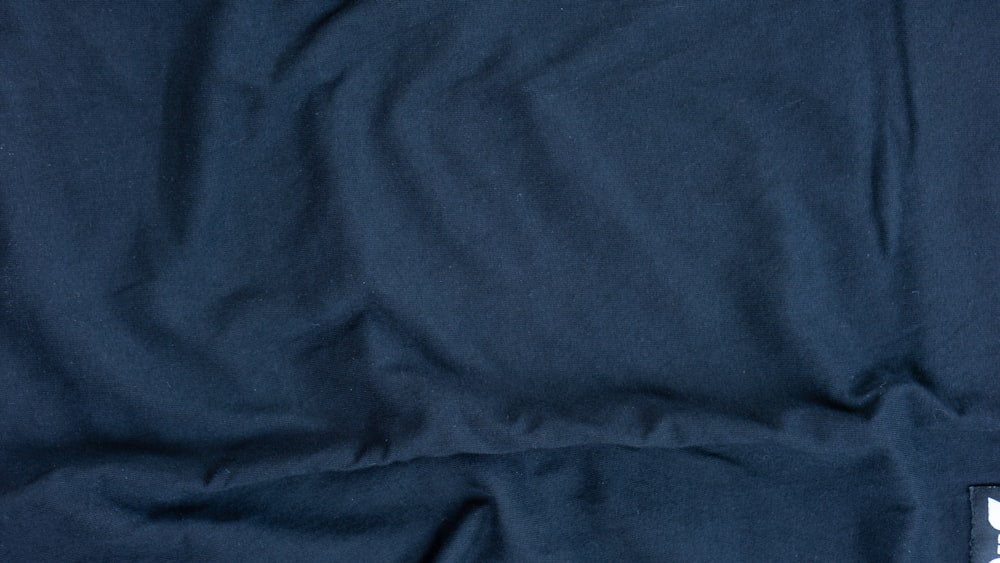 a close up of a blue shirt with a white logo on it