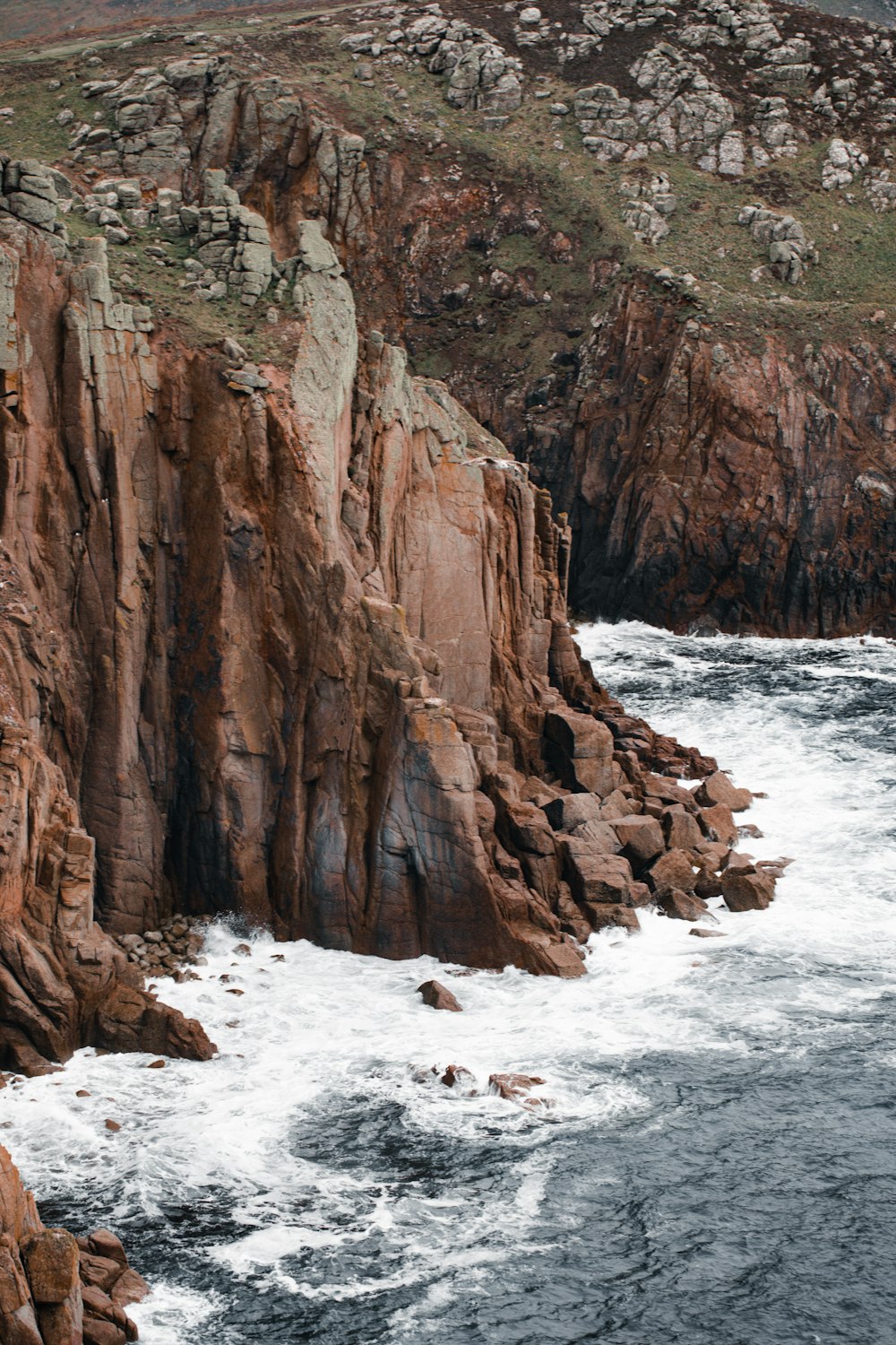 a large body of water next to a rocky cliff