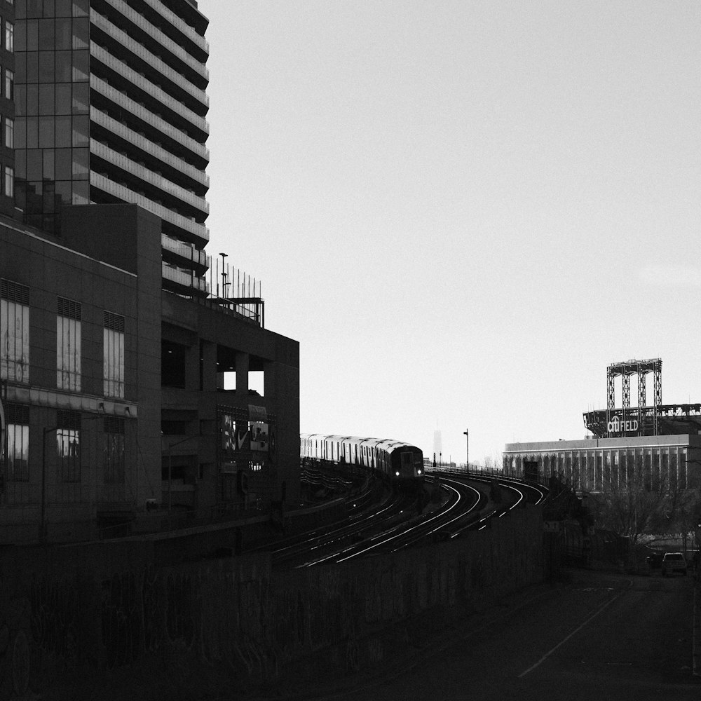 a black and white photo of a train going down the tracks