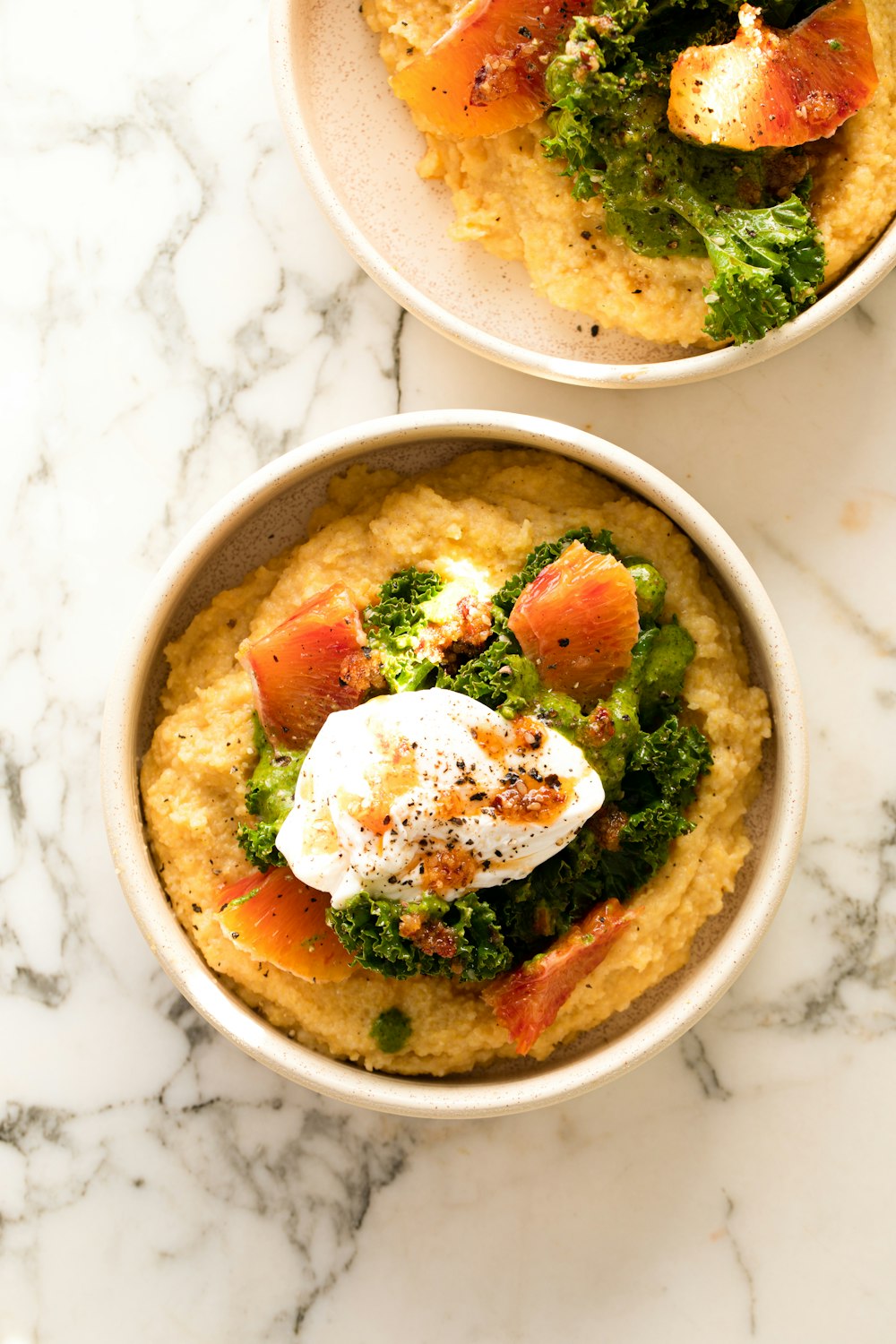 two bowls of food on a marble table