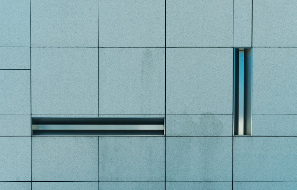 a close up of a blue wall with a window