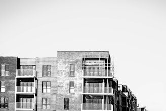 a black and white photo of a row of apartment buildings