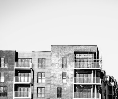 a black and white photo of a row of apartment buildings