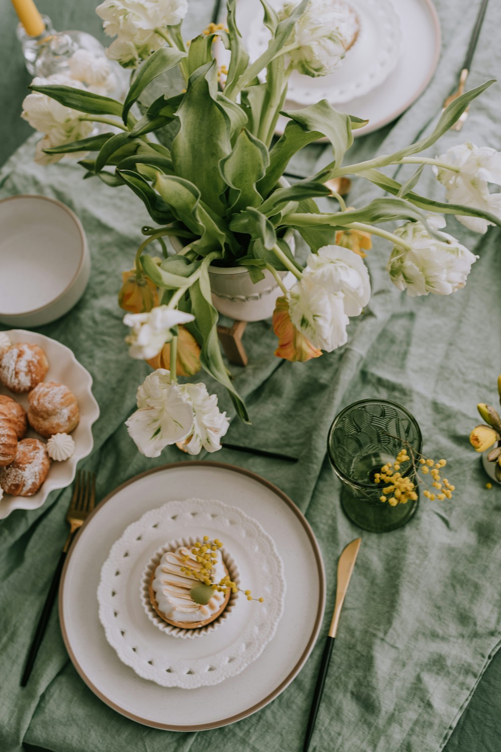 a table topped with plates of food and flowers