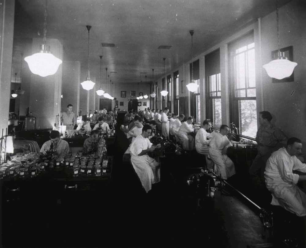 a black and white photo of a group of people in a room
