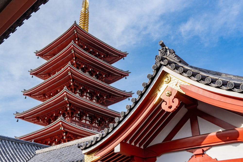 a tall red and white building next to a tall tower