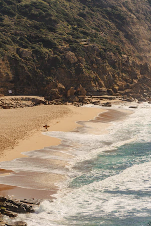 a person walking along a beach next to the ocean