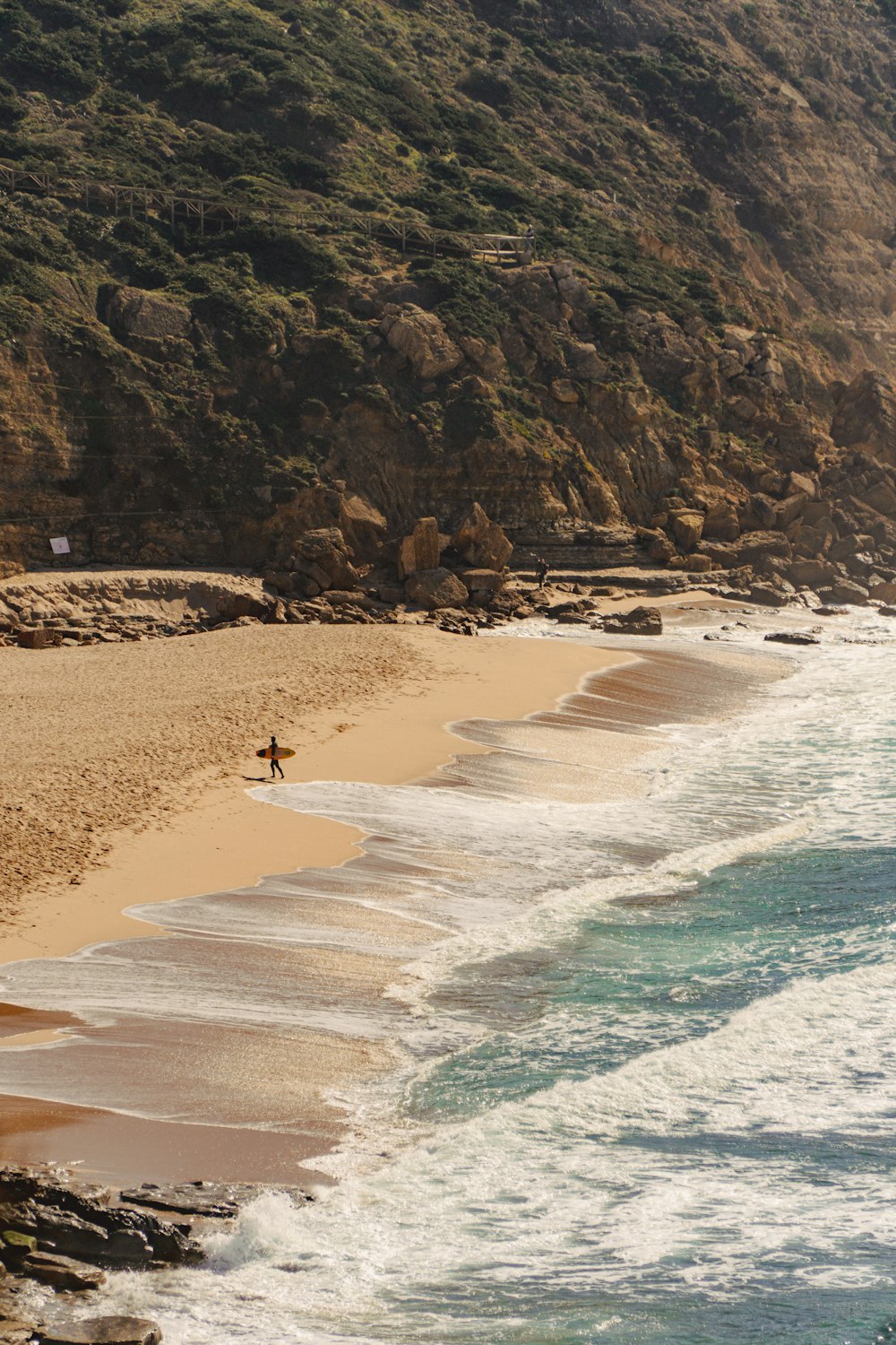 Una persona caminando por una playa junto al océano