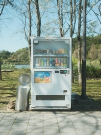 Technician performing maintenance on a vending machine in an industrial park.