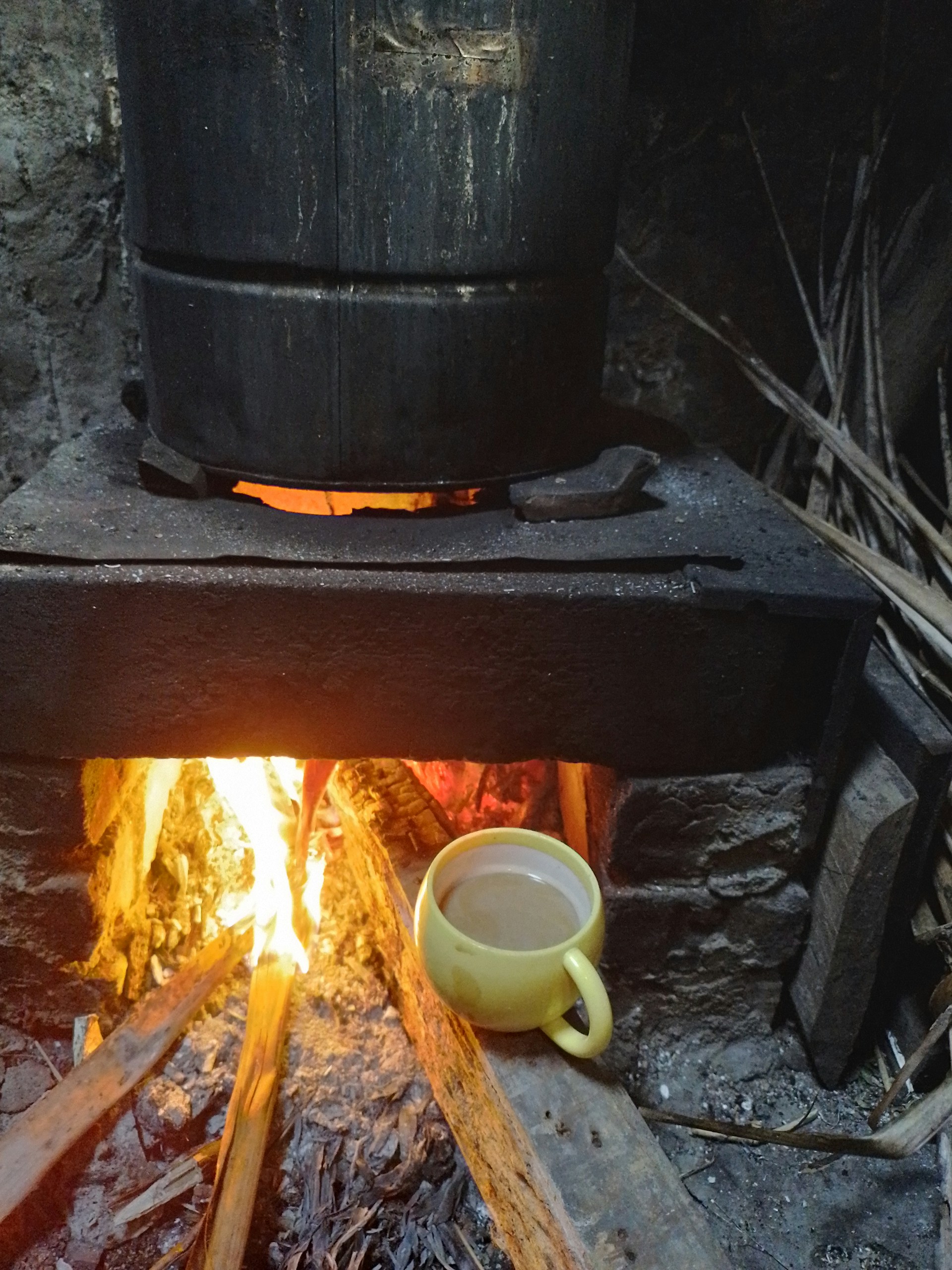 The warm glow of a wood-fired stove where coffee beans are being carefully roasted by hand, capturing the old-fashioned method of 'd vargas cosecha'.