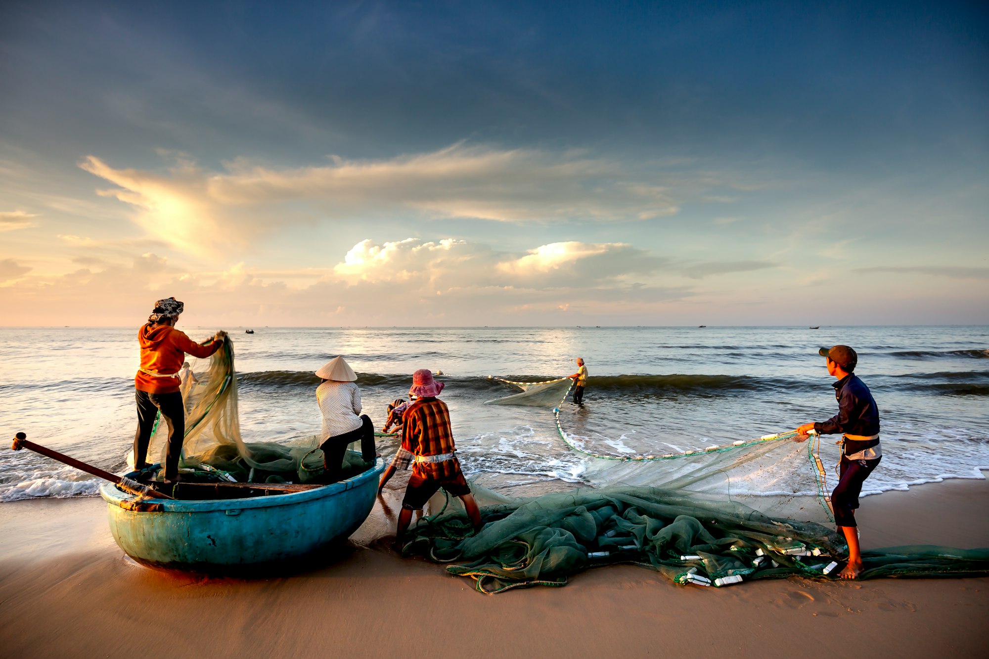 Beach Lagi, Binh Thuan province, Vietnam - August 29, 2015: Unknown Fishermen who pull up th are the fishing nets khi sunrise. This is ask for their daily work