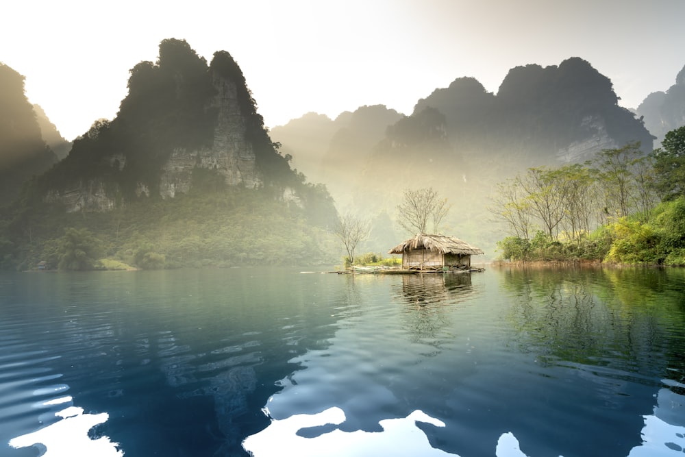 a small hut on a small island in the middle of a lake