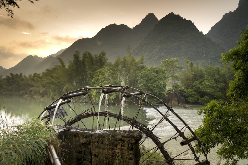 a water wheel sitting on the side of a river