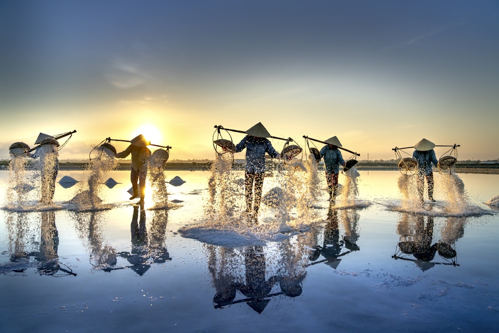 um grupo de pessoas em pé em cima de um corpo de água