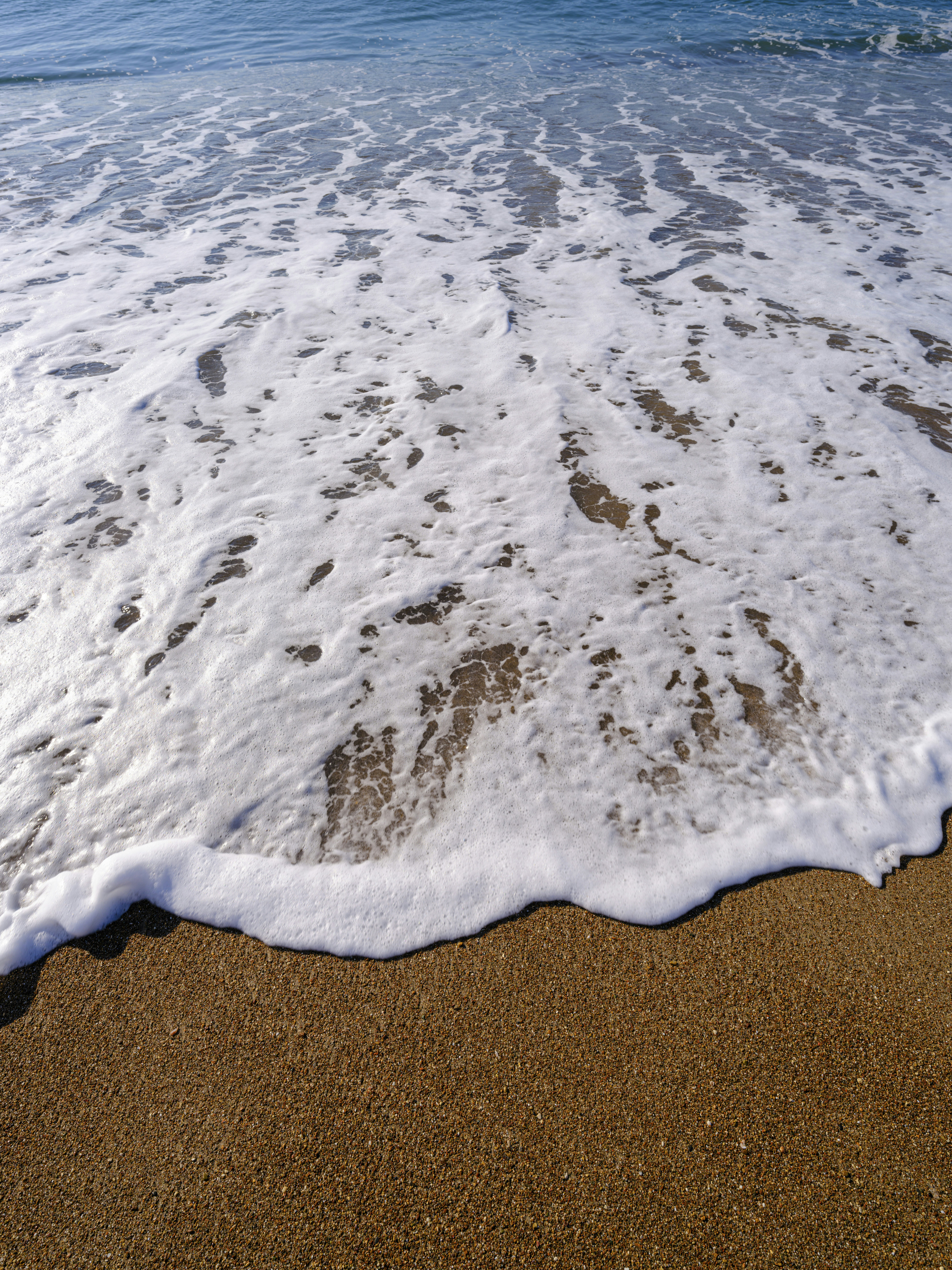 a sandy beach with waves coming in to shore