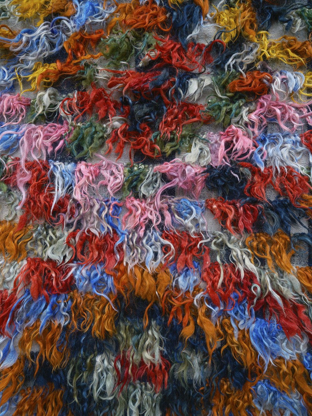 a pile of multicolored yarn is laying on the ground