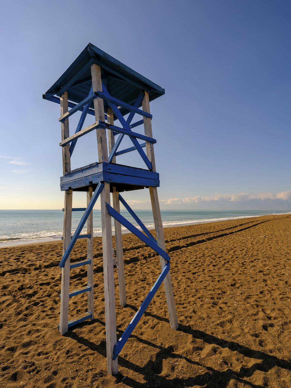 Una torre de salvavidas en una playa con el océano al fondo