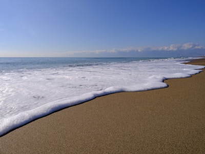 A serene beach scene with waves gently lapping the shore.