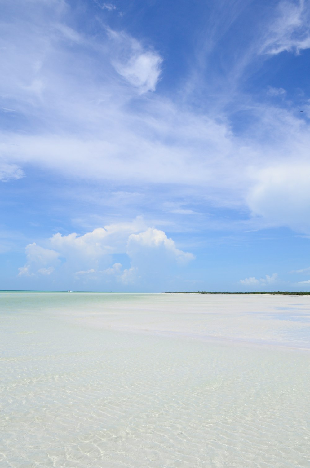 a beach with a boat in the middle of the water