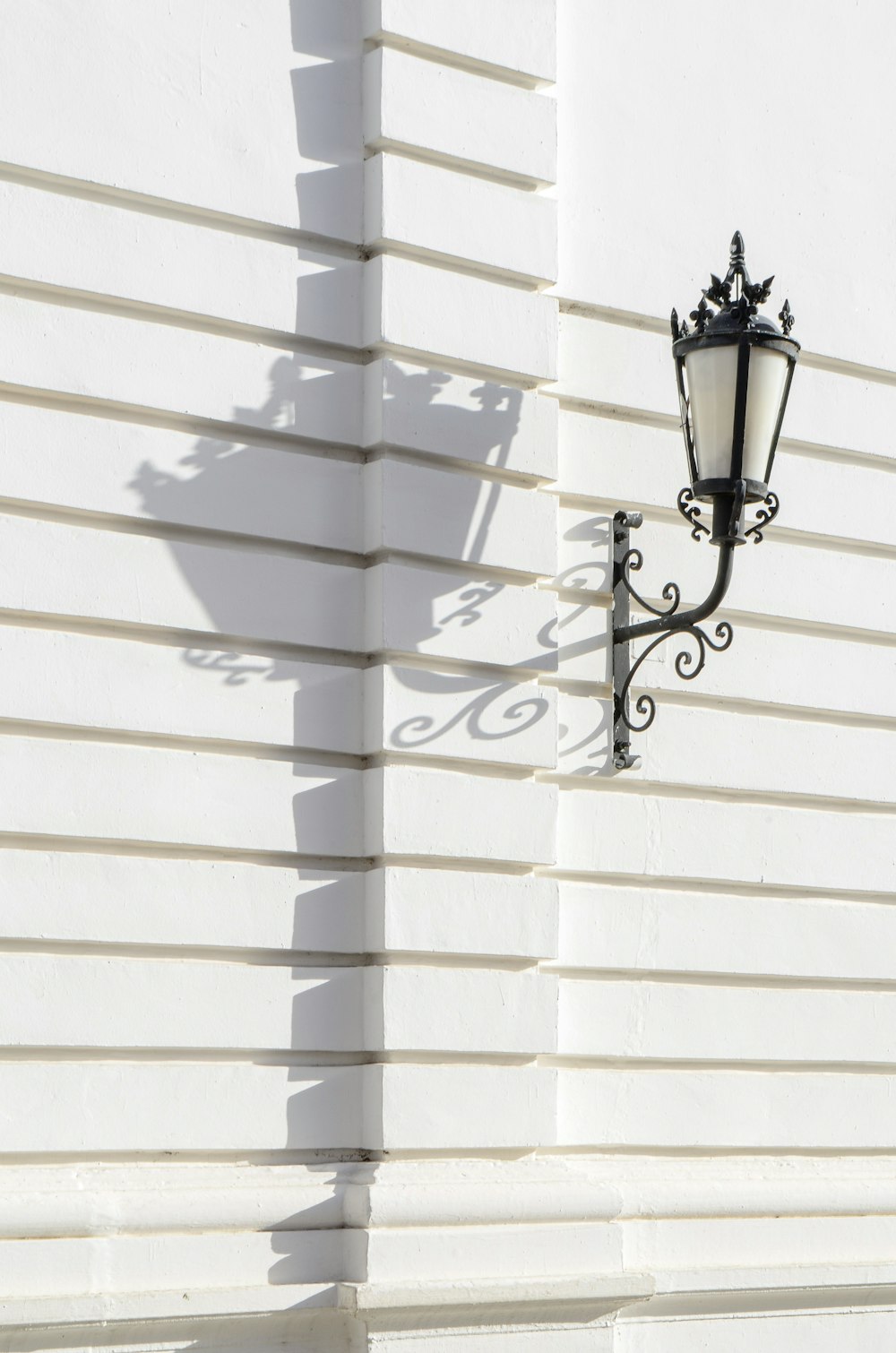 a street light on the side of a white building