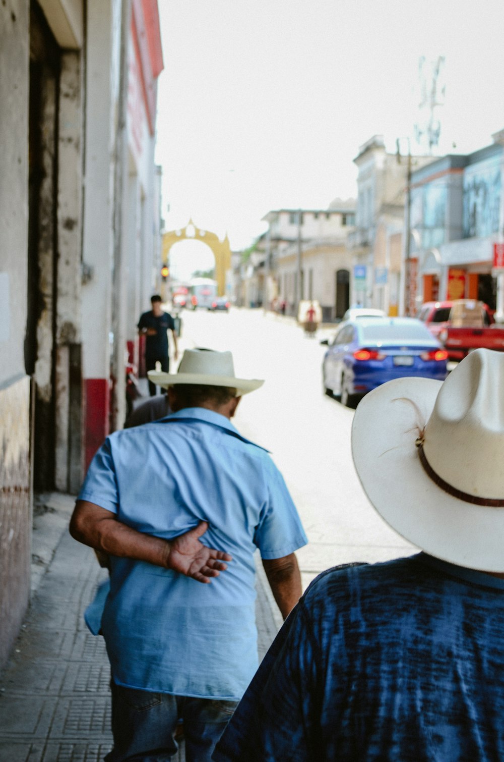 a couple of men walking down a street next to a tall building