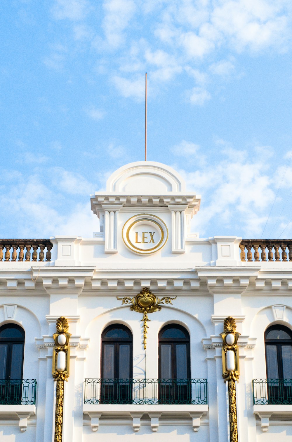 a large white building with a clock on the top of it