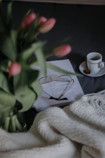A cozy home corner with a nurse's stethoscope resting beside a baby blanket and a cup of tea.