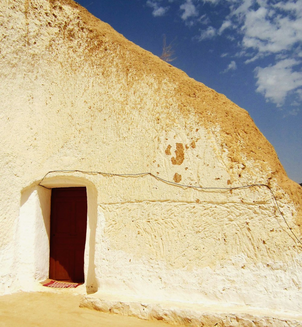 a small white building with a red door