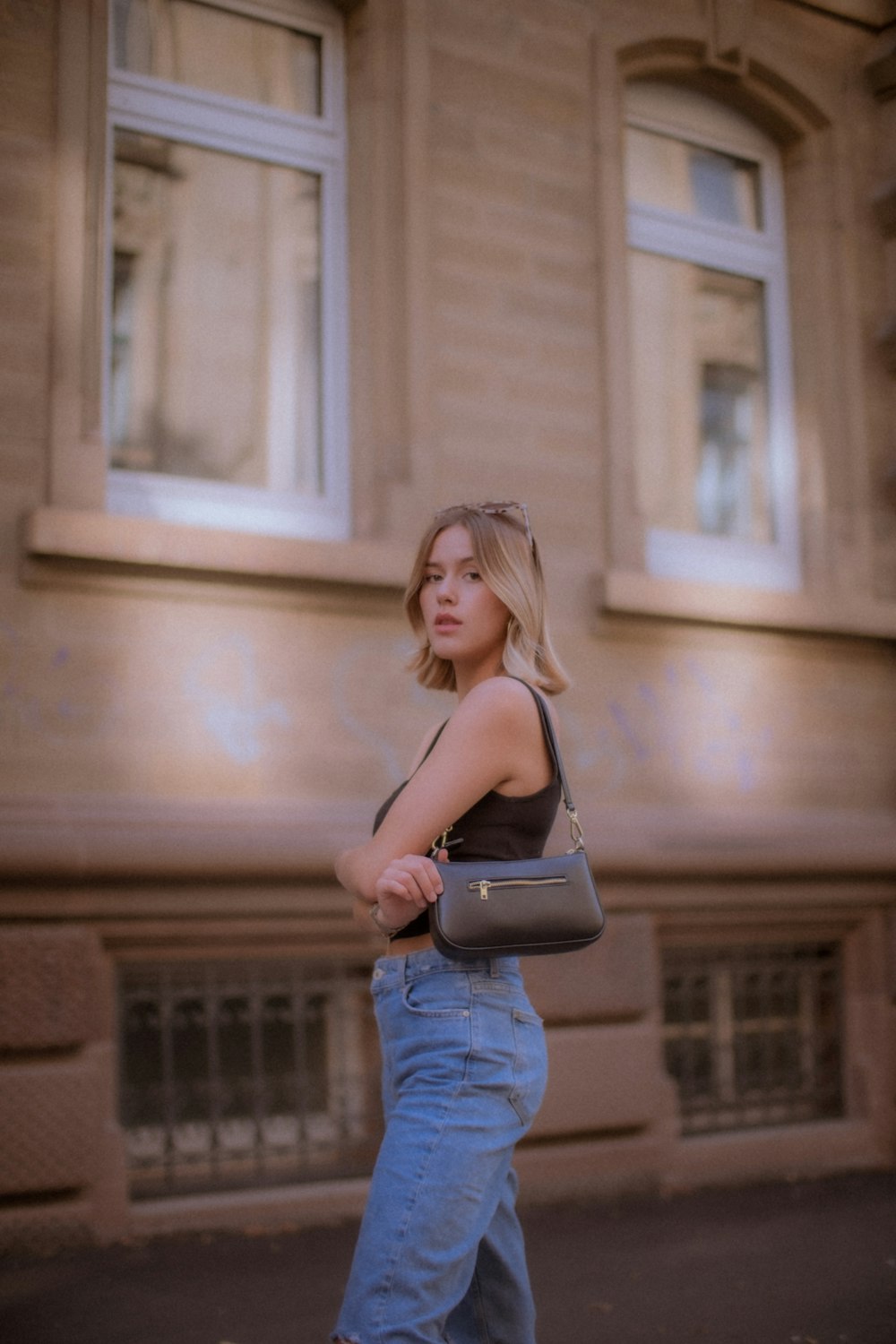 a woman is walking down the street with a purse