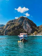 A vibrant photo of a boat cruising along Samaná Bay with lush green hills in the background under a clear blue sky.