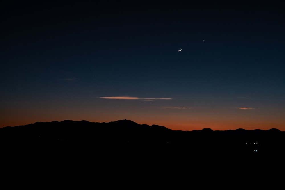 the sun is setting over a mountain range