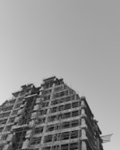 Photo of a modern building under construction with scaffolding and workers.