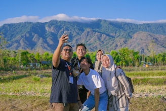 A diverse group of friends laughing together on a scenic mountain hike during a group tour.