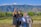 Group of happy travelers posing in front of a scenic mountain backdrop