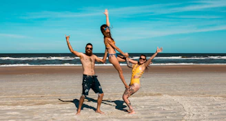 a group of people having fun on a sandy beach