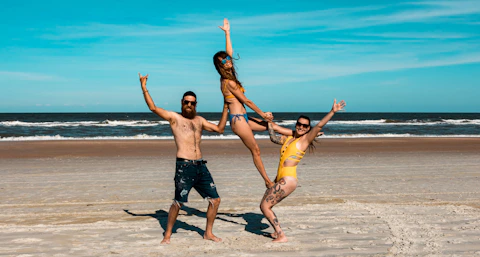 a group of people having fun on a sandy beach
