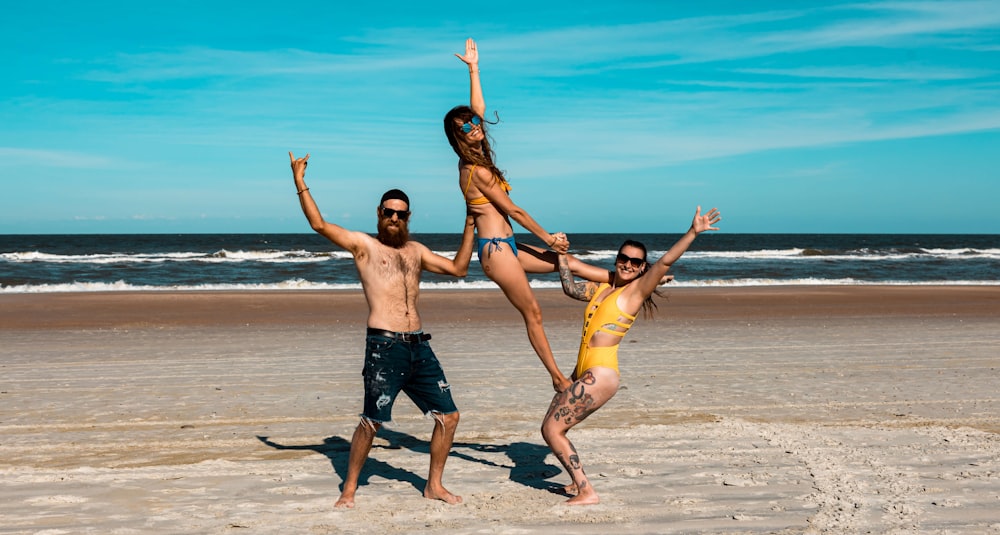 a group of people standing on top of a sandy beach