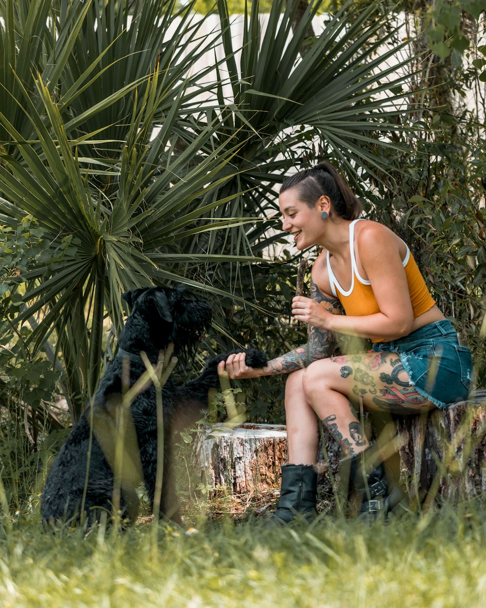 a woman sitting on a bench next to a black dog