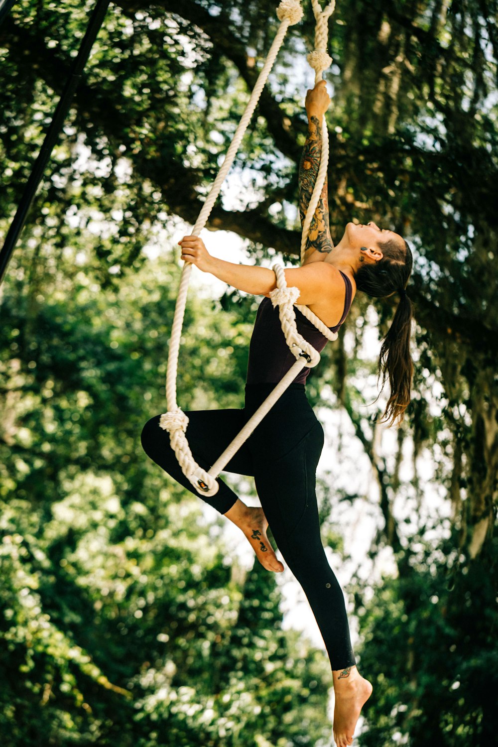 a woman on a rope swing in the woods