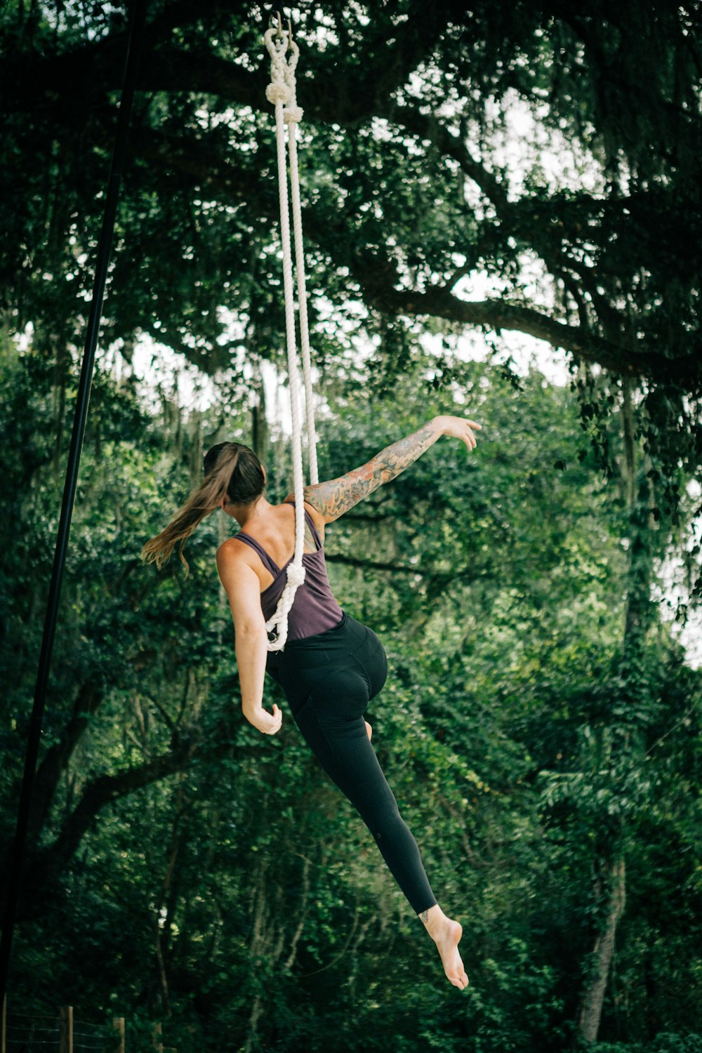 a woman hanging from a rope in the air
